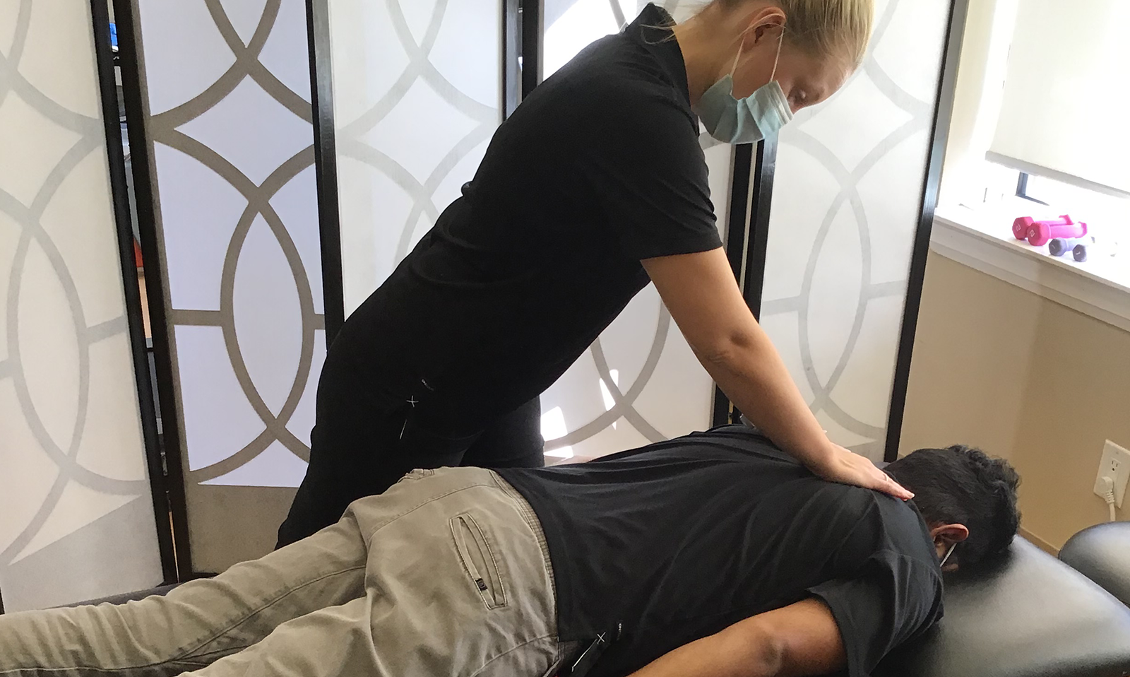 chiropractor helping a patient on the bed