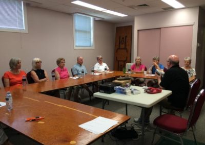 wefixu staff explains to a group of elderly about physiotherapy in a big table